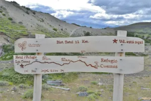 Un grupo de excursionistas recorre el sendero panorámico entre Las Torres y Los Cuernos con el Macizo del Paine al fondo.