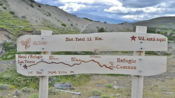 A group of hikers navigating the scenic trail between Las Torres and Los Cuernos with the Paine Massif in the background.