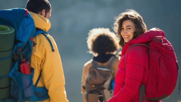 Retrato de una excursionista sonriente, con el escarpado paisaje de las montañas patagónicas de fondo.
