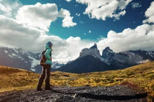 Un excursionista solitario recorre un estrecho sendero de tierra con los majestuosos picos de granito alzándose imponentes ante él.