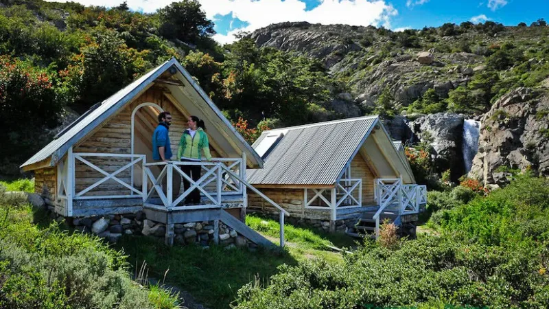 Un acogedor interior de cabaña de madera en Cabañas Los Cuernos con vistas al bosque circundante.