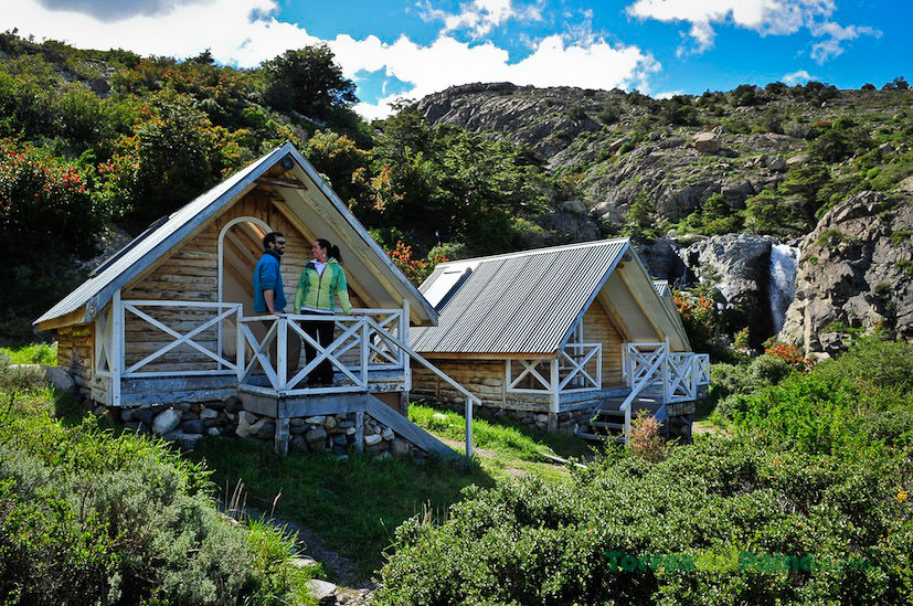A cozy wooden cabin interior at Cabañas Los Cuernos with views of the surrounding forest.
