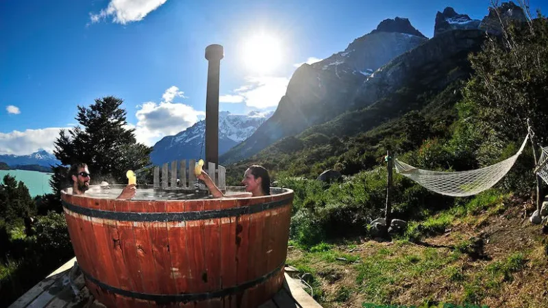 Un conjunto de cabañas rústicas de madera en Cabañas Los Cuernos, al pie de las montañas de granito.