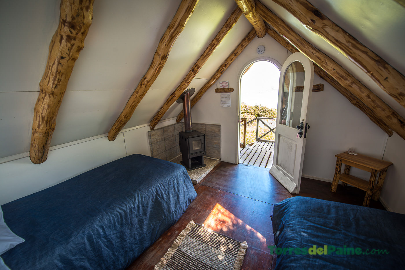 A small porch of a wooden cabin at Los Cuernos overlooking the surrounding Patagonian wilderness.
