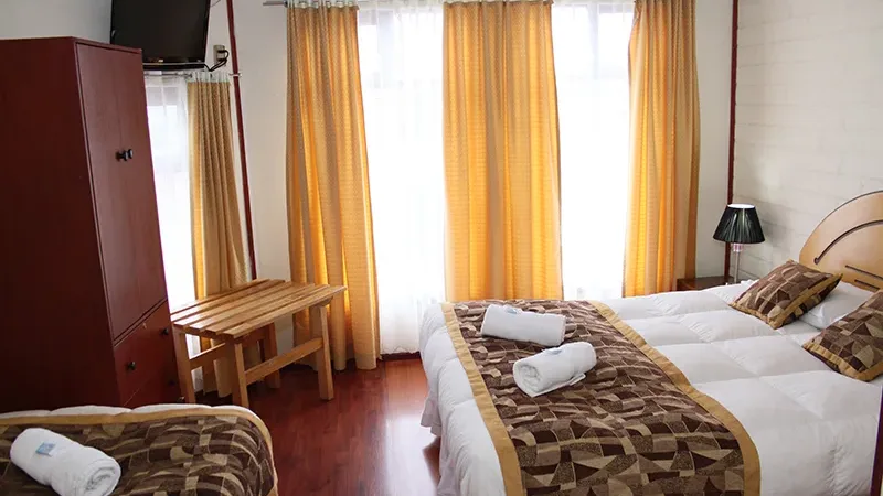 La acogedora entrada y la fachada clásica del Hostal Alcázar en Puerto Natales.