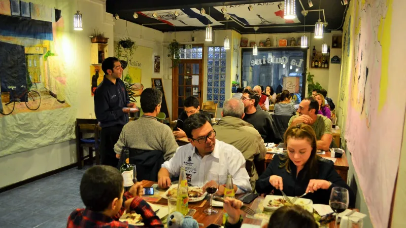 Uma seleção de pães artesanais e aperitivos em uma tábua de madeira no La Cuisine.