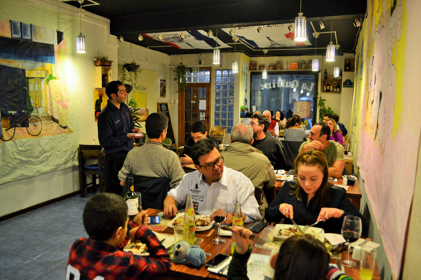 A selection of artisanal breads and appetizers on a wooden board at La Cuisine.