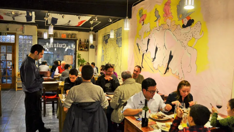 A sinalização externa e a fachada do restaurante La Cuisine durante a noite.