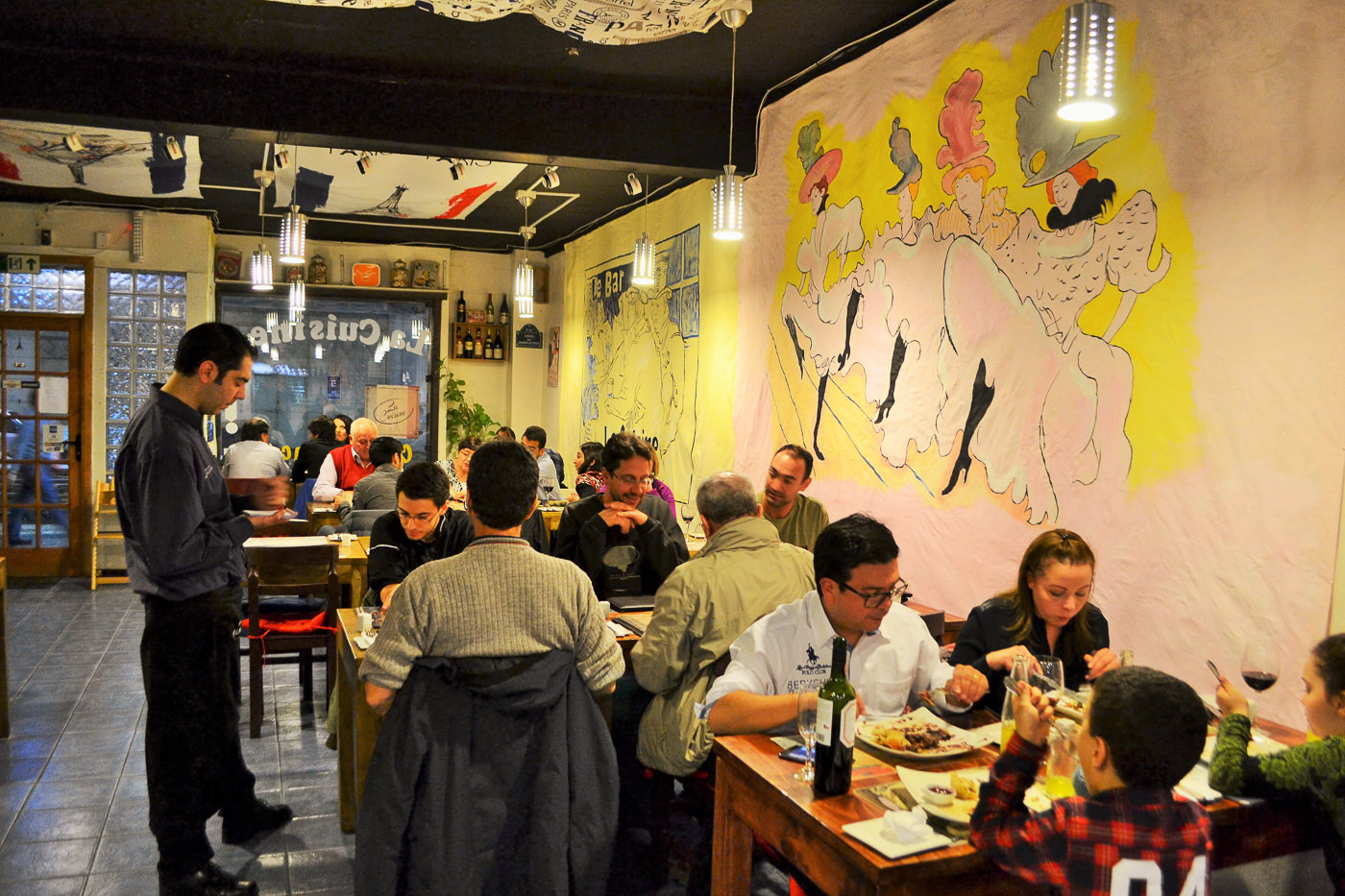 The outdoor signage and facade of La Cuisine restaurant during the evening.