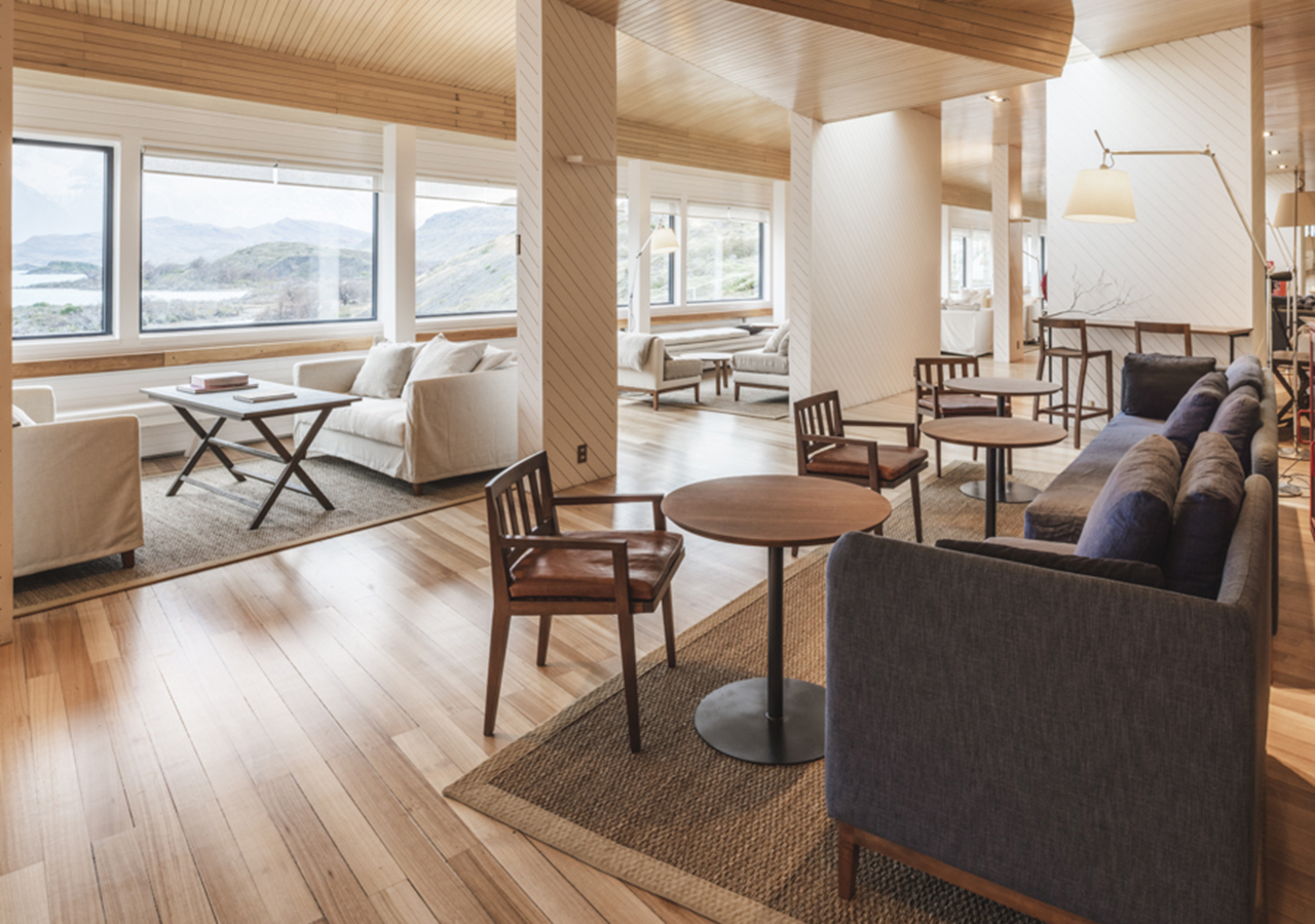 El salón del hotel cuenta con amplias paredes de cristal y cómodos asientos modernos.