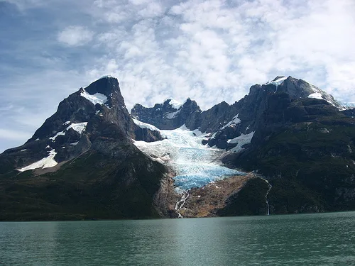 Uma vista panorâmica da geleira Balmaceda, suspensa na encosta de uma montanha sobre o fiorde.