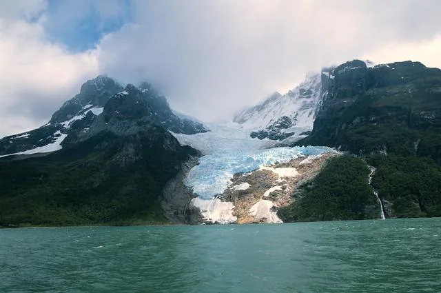 A geleira Serrano desaguando em uma lagoa tranquila repleta de pequenos icebergs.