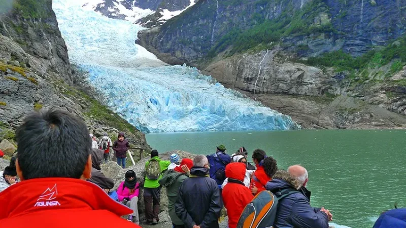 Un barco navegando por las profundas aguas azules del estrecho de Última Esperanza, cerca de los glaciares.