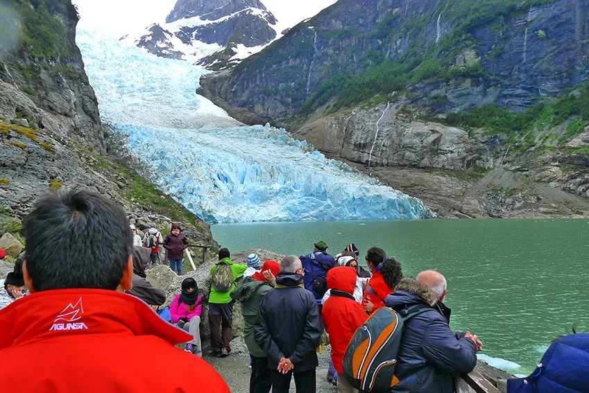 Un barco navegando por las profundas aguas azules del estrecho de Última Esperanza, cerca de los glaciares.