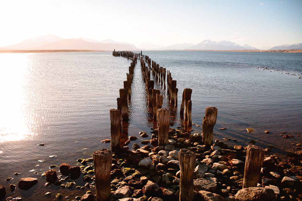 Las vastas y profundas aguas azules del fiordo Seno Última Esperanza, rodeadas de montañas.