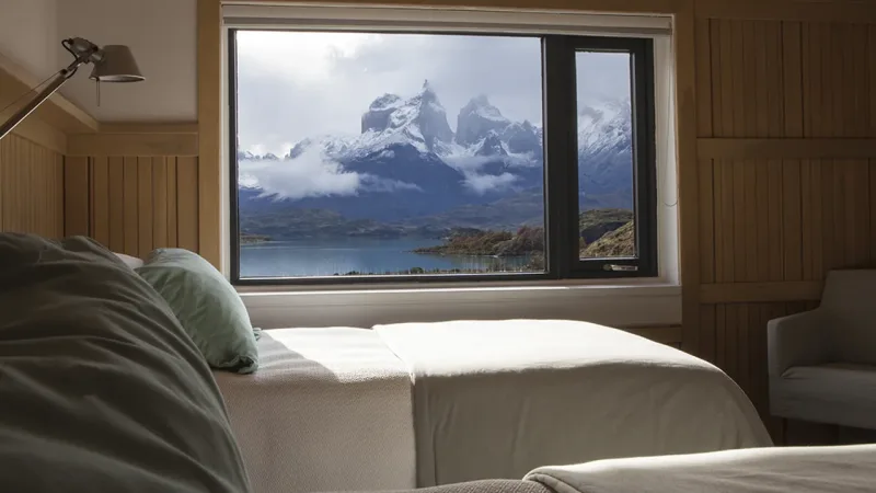 Quarto com duas camas de solteiro no Hotel Explora, com design minimalista em madeira e vista panorâmica para a montanha.