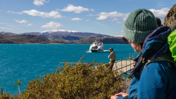 Pasajeros en la cubierta del barco Pehoé con los Cuernos del Paine al fondo.