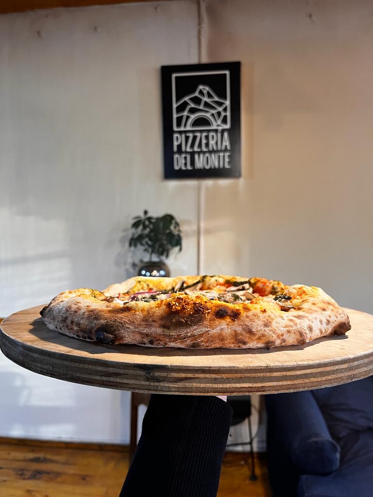 Exterior de la Pizzería del Monte, donde se aprecia su encantadora fachada de estilo patagónico.