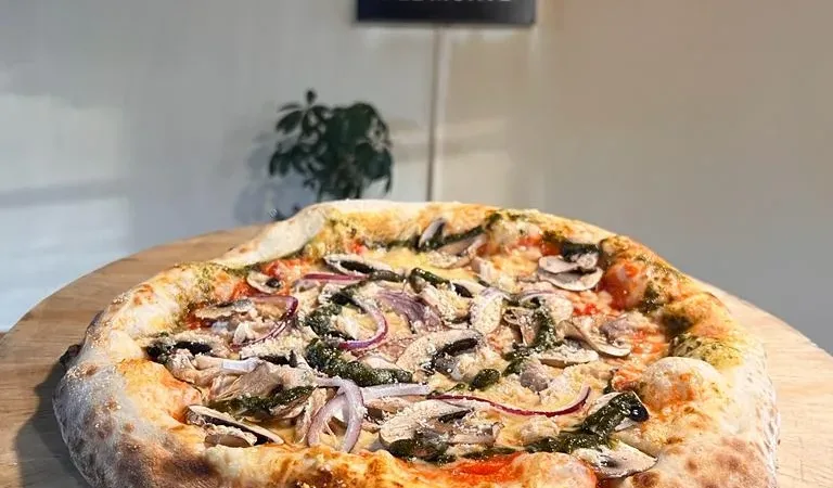 El comedor se llenó de clientes satisfechos que disfrutaban de la pizza en un ambiente cálido.