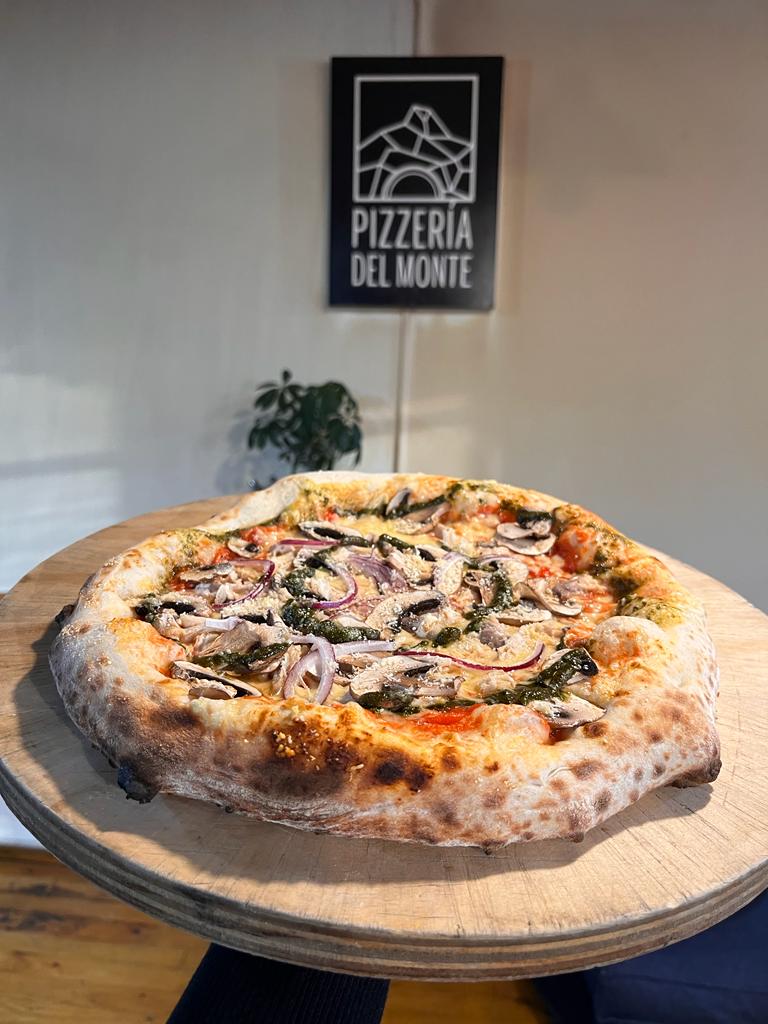 El comedor se llenó de clientes satisfechos que disfrutaban de la pizza en un ambiente cálido.