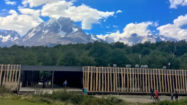 A área de jantar do Restaurante Rio Pingo apresenta grandes janelas e mobiliário rústico.
