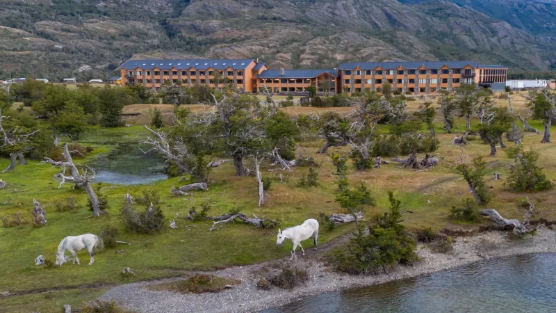 The grand exterior of Hotel Río Serrano with its distinctive wooden and stone architecture.