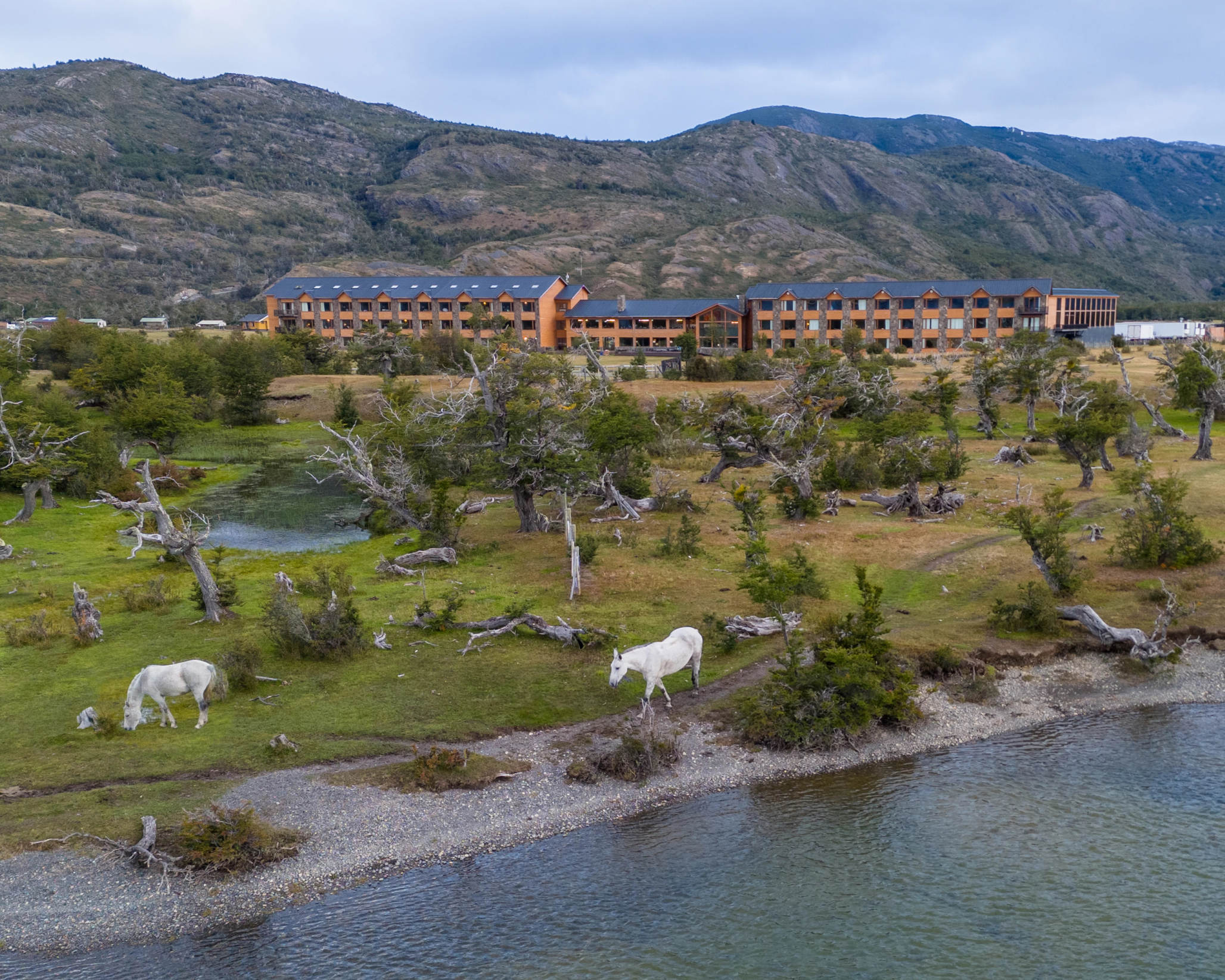 The grand exterior of Hotel Río Serrano with its distinctive wooden and stone architecture.