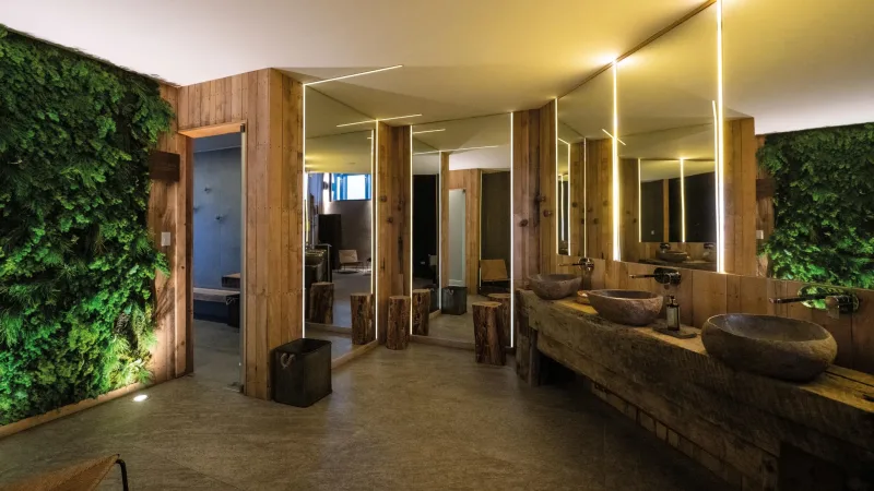 A well-appointed guest room with warm lighting and a large window facing the mountains.