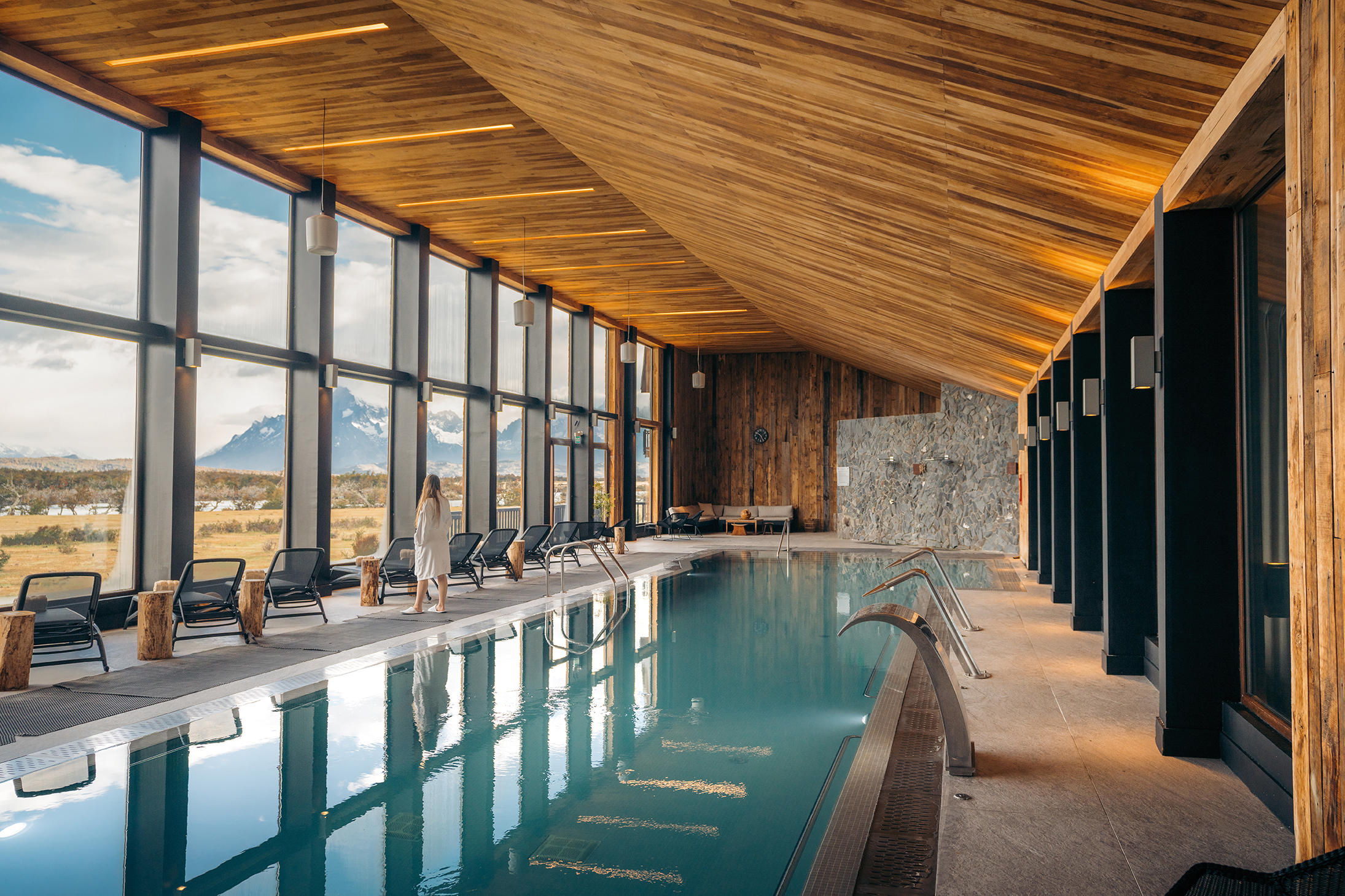 Modern ensuite bathroom at Hotel Río Serrano with clean white tiles and a glass shower.