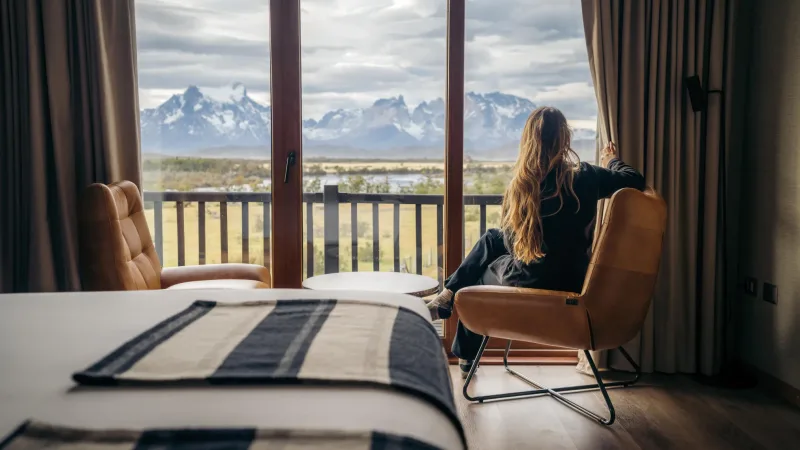 An indoor jacuzzi with large windows overlooking the Patagonian wilderness.