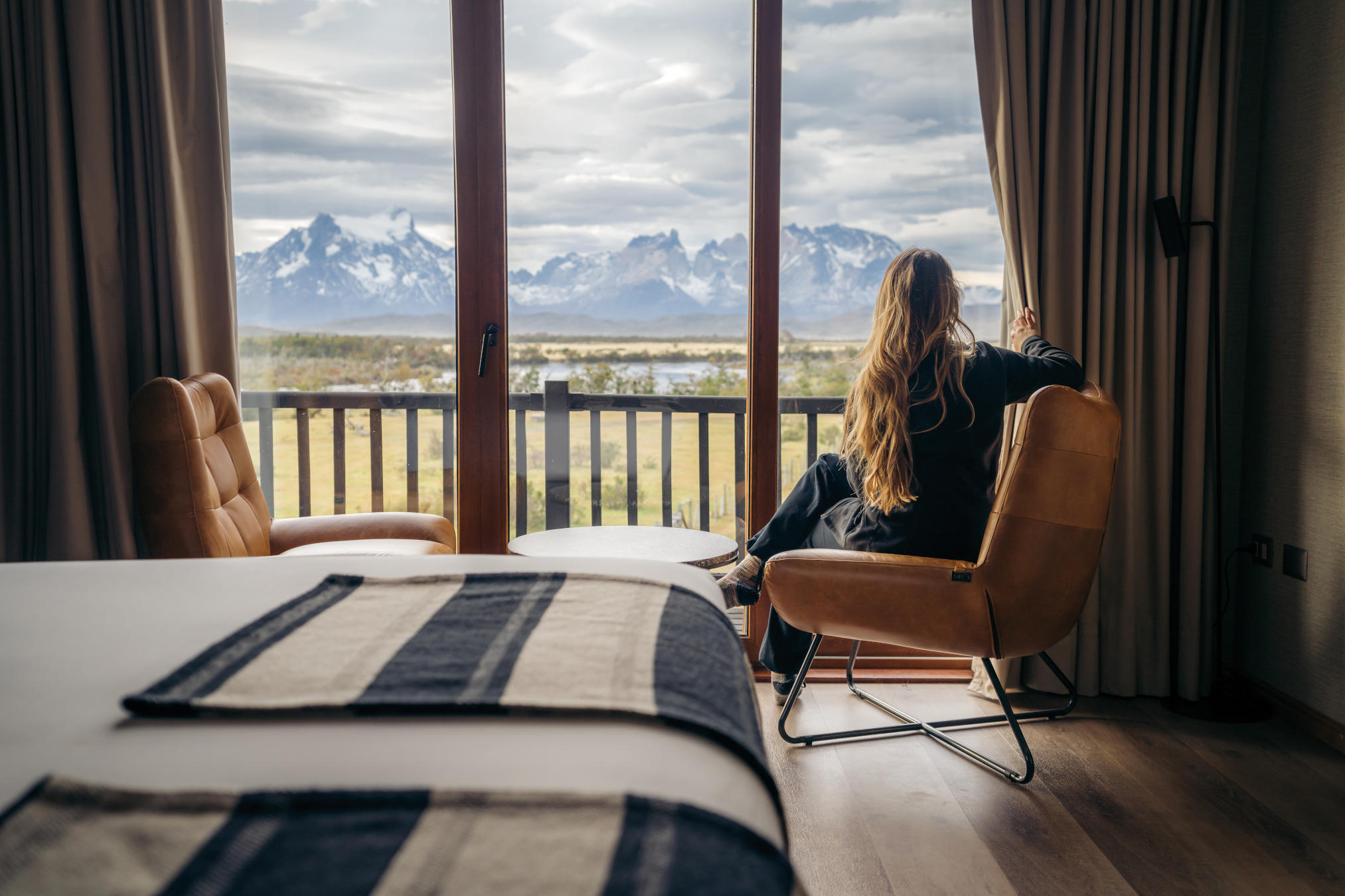 An indoor jacuzzi with large windows overlooking the Patagonian wilderness.