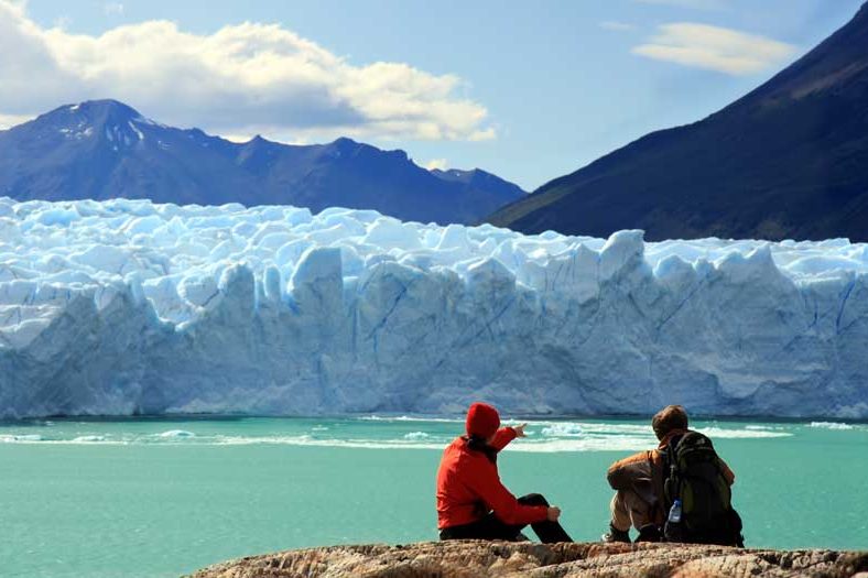Una toma panorámica del glaciar Perito Moreno que muestra su inmensa magnitud contra las montañas.