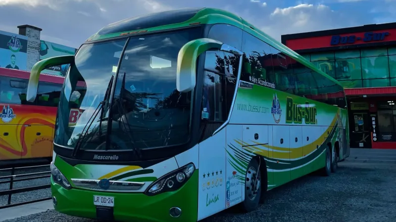 Vista de vários ônibus da Bus Sur enfileirados na garagem de Punta Arenas.