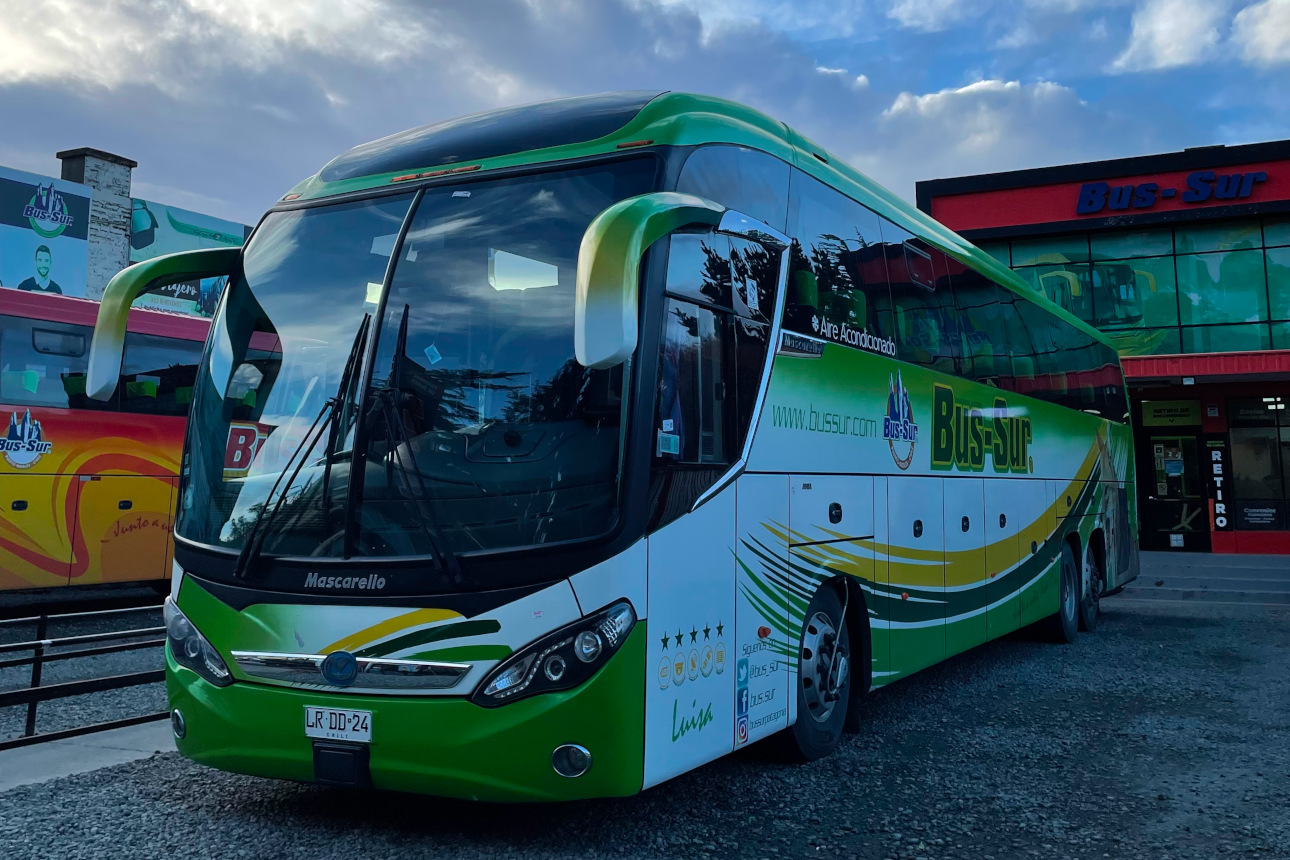 Vista de vários ônibus da Bus Sur enfileirados na garagem de Punta Arenas.