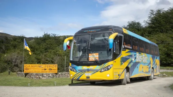 La zona de la parada de autobús en Laguna Amarga, con un autobús de la compañía Bus Sur en primer plano.