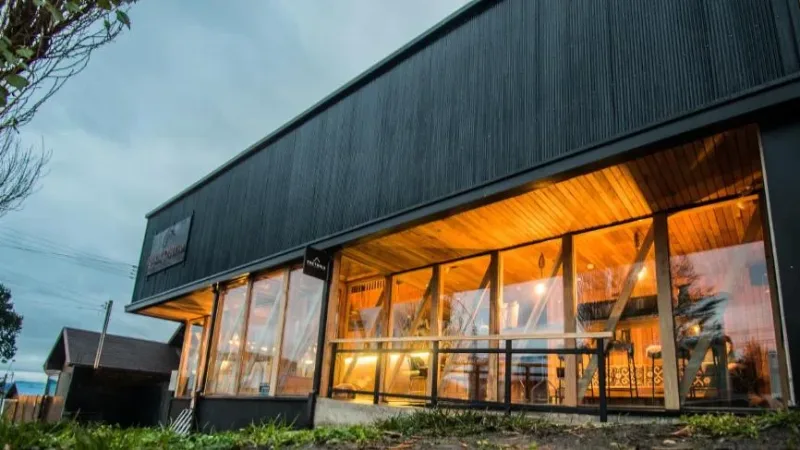 Um aconchegante lounge para hóspedes com móveis artesanais locais no Factoria Patagonia.