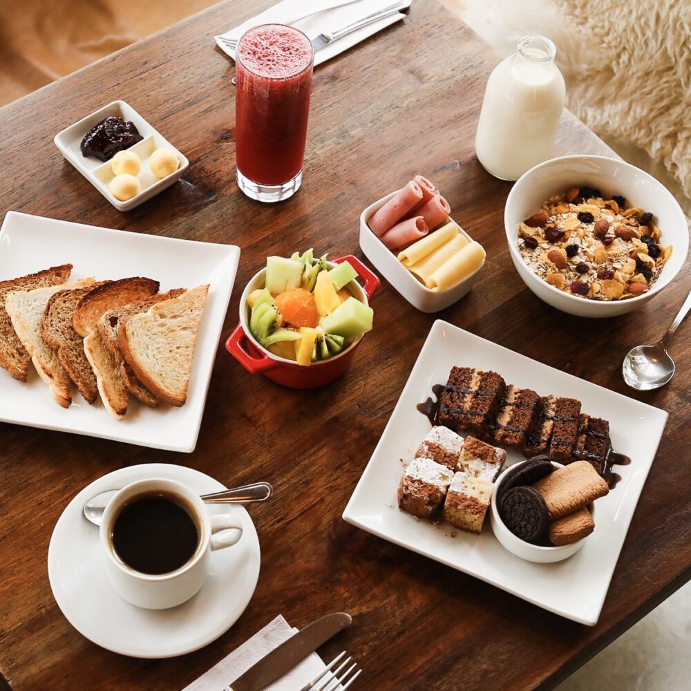 Un desayuno saludable con zumo natural, café y bollería en un albergue local.