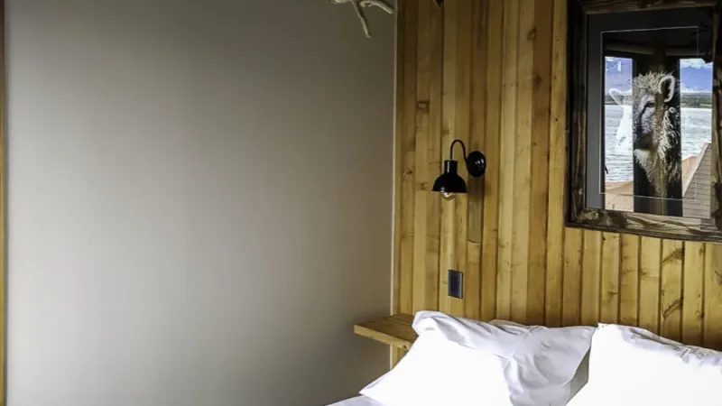 A modern dormitory room with clean lines and wooden bunks at Factoria Patagonia.