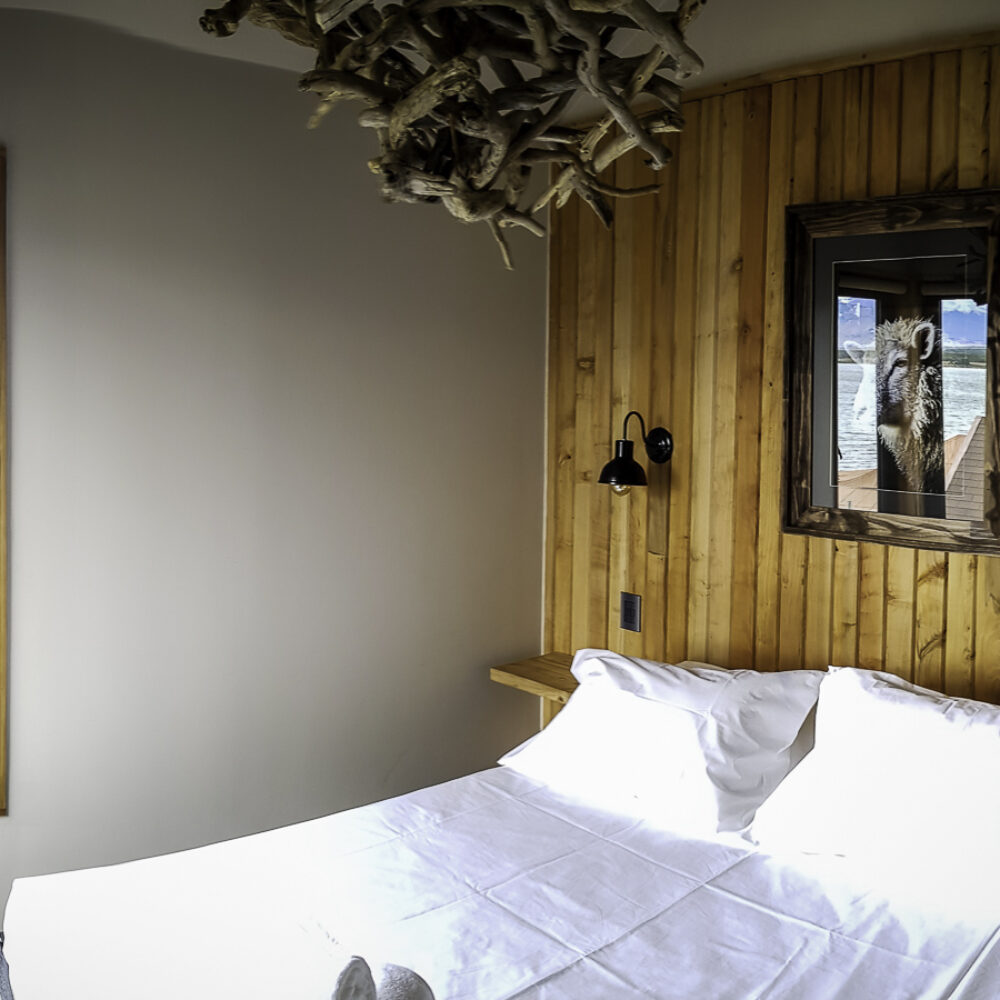 Una habitación de residencia estudiantil moderna con líneas sencillas y literas de madera en Factoria Patagonia.