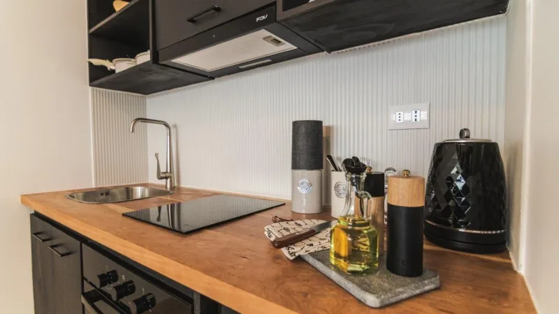 Una cocina moderna y bien equipada en Loft Toore Patagonia, con electrodomésticos de acero inoxidable y encimeras de madera.