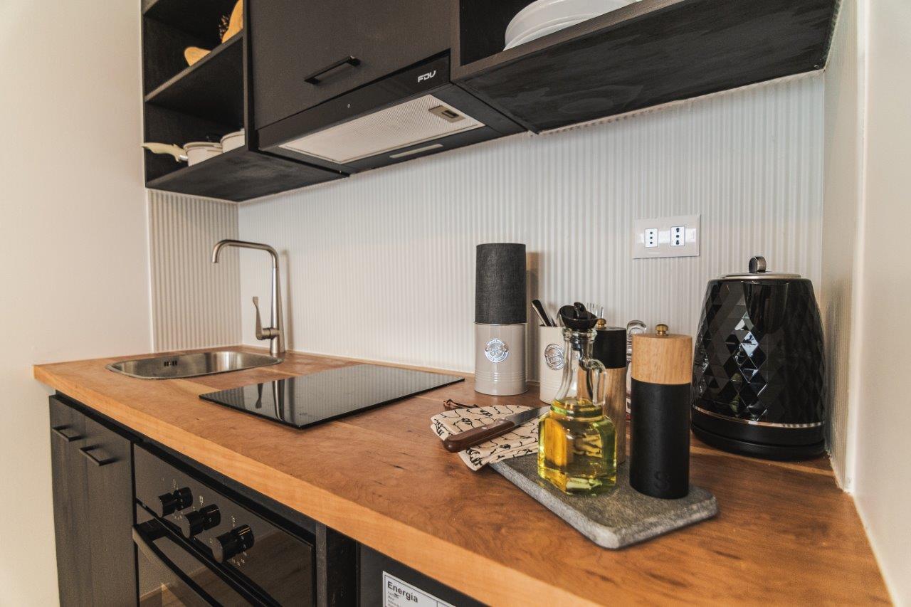 Una cocina moderna y bien equipada en Loft Toore Patagonia, con electrodomésticos de acero inoxidable y encimeras de madera.