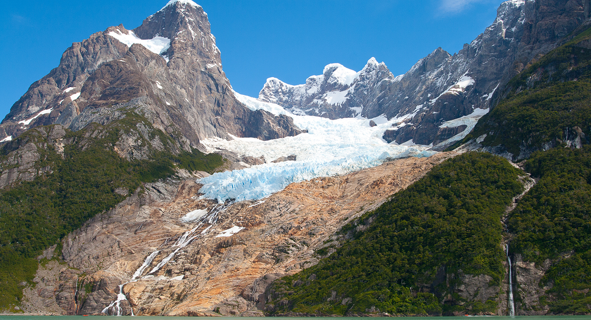 A large boat navigating the calm waters of the fjord on the way to Balmaceda and Serrano Glaciers.