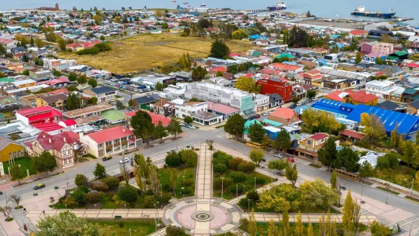 El monumento central en la Plaza Muñoz Gamero, rodeado de árboles altos en Punta Arenas.