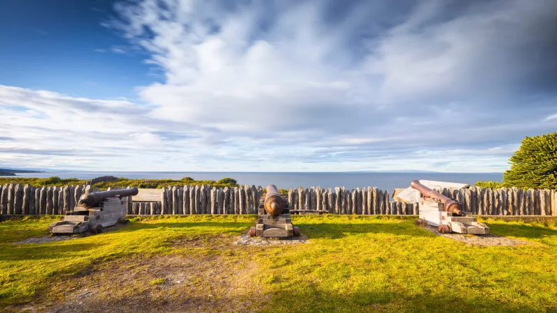 Old iron cannons positioned on the defensive walls of Fuerte Bulnes.