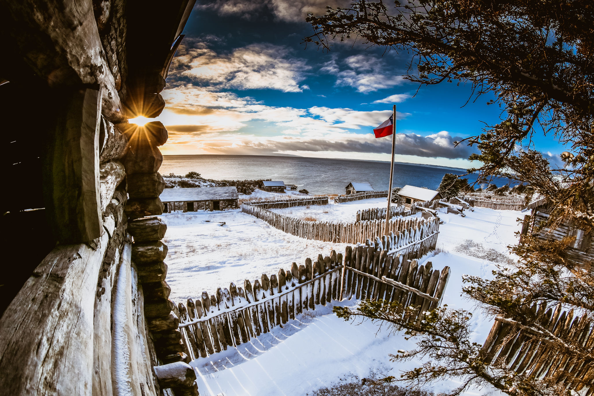 The wooden buildings of Fuerte Bulnes covered in a light layer of winter snow.