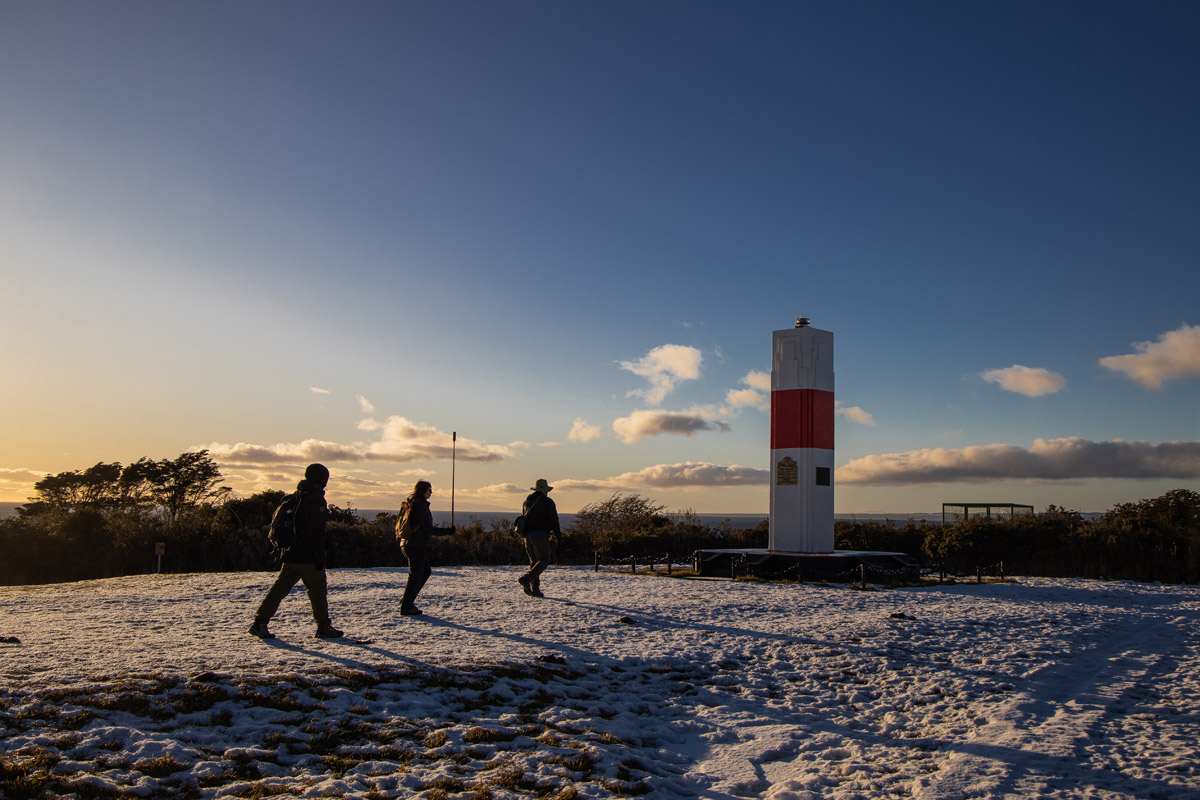 The small red and white lighthouse named after Bernardo O'Higgins on the rocky coast.