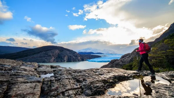 Hiker with trekking poles overlooking Grey Glacier and lake on the W Circuit trek in Torres del Paine, Patagonia